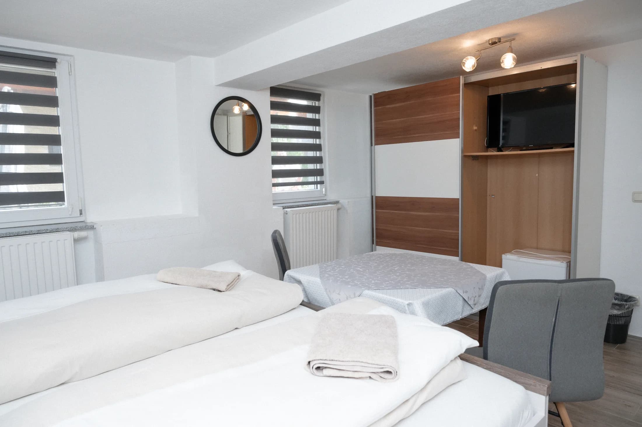 Zimmer mit Kleiderschrank, Spiegel und Flat-TV
